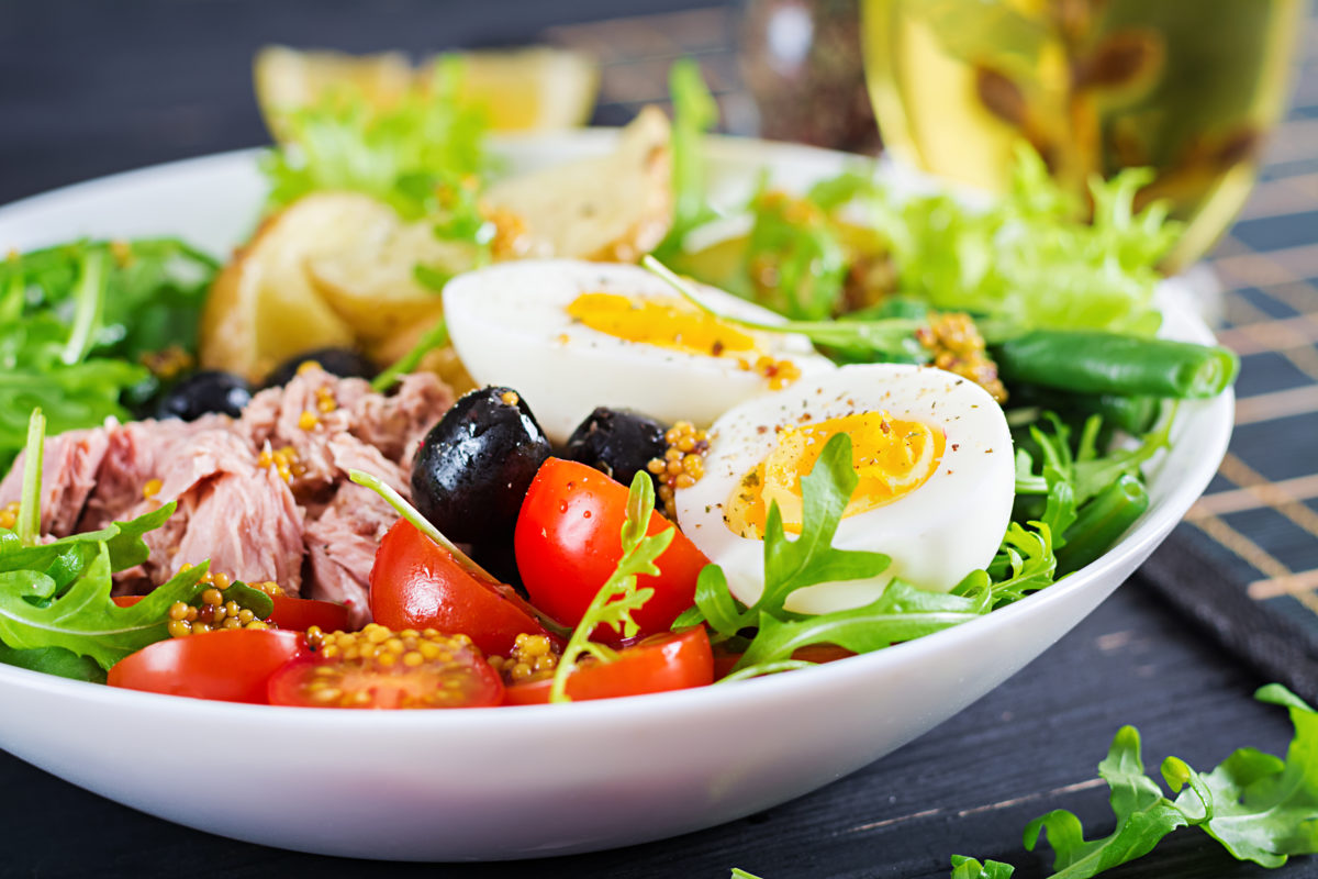 healthy-hearty-salad-of-tuna-green-beans-tomatoes-eggs-potatoes-black-olives-close-up-in-a-bowl-on-the-table-1200x800.jpg